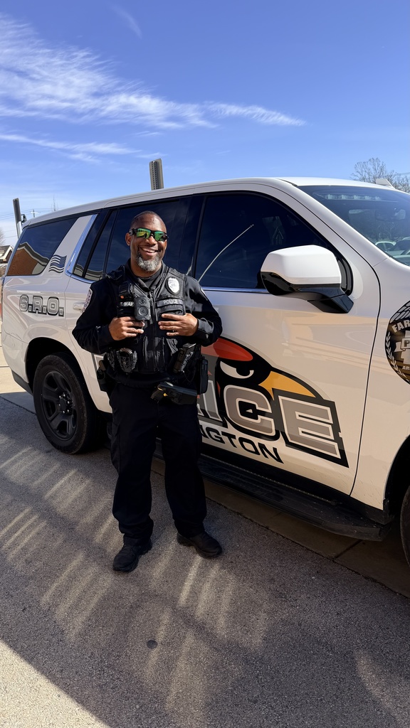 officer posing in front of cruiser 