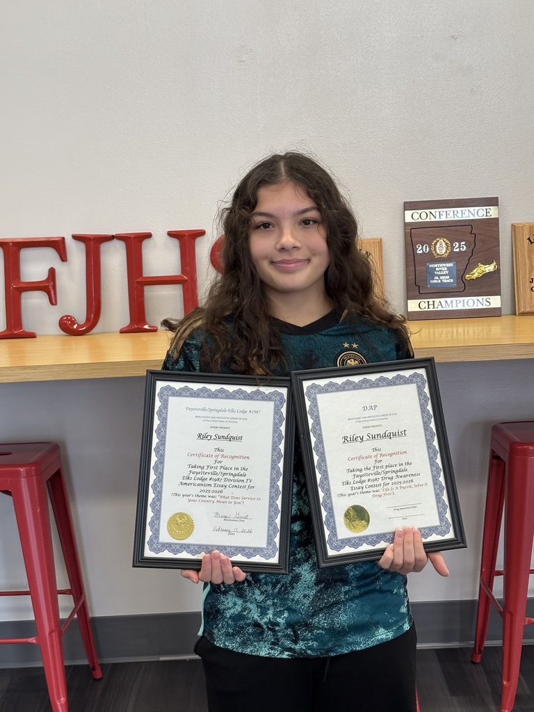 Student holding 2 certificates of recognition