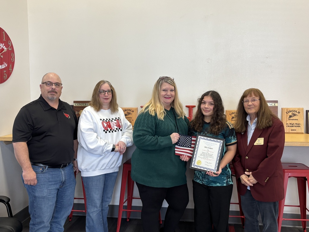 Student holding certificate of recognition with others