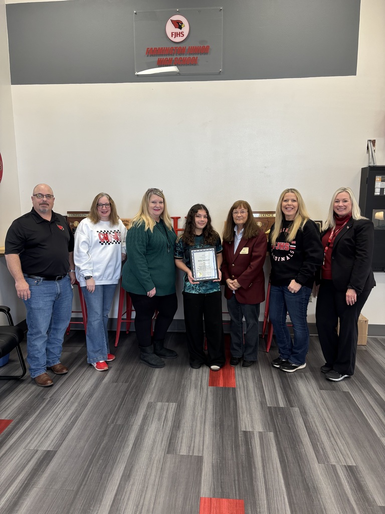 Student holding certificate of recognition with others