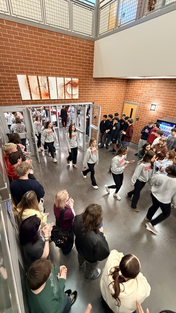 student body clapping as team walks by