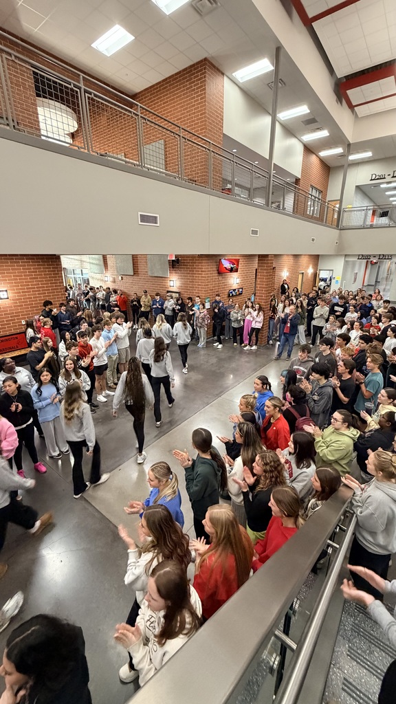student body clapping as team walks by