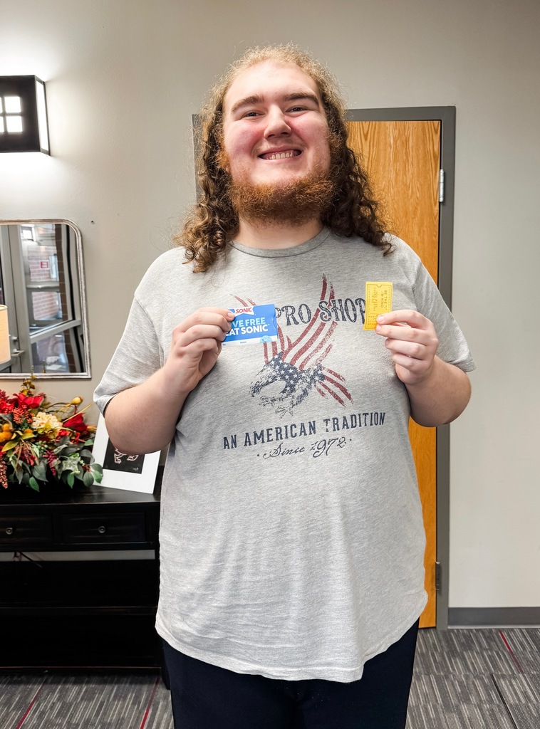 student posing with prize