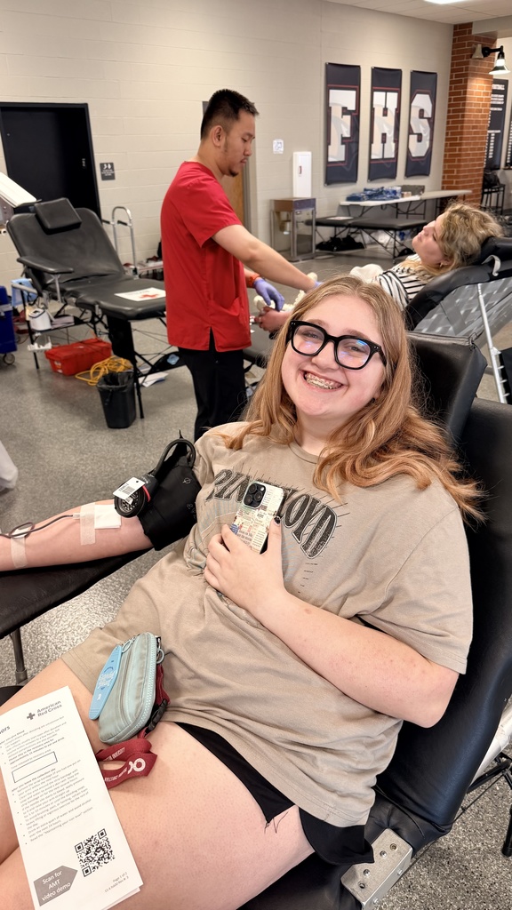 student posing as she gets her blood drawn