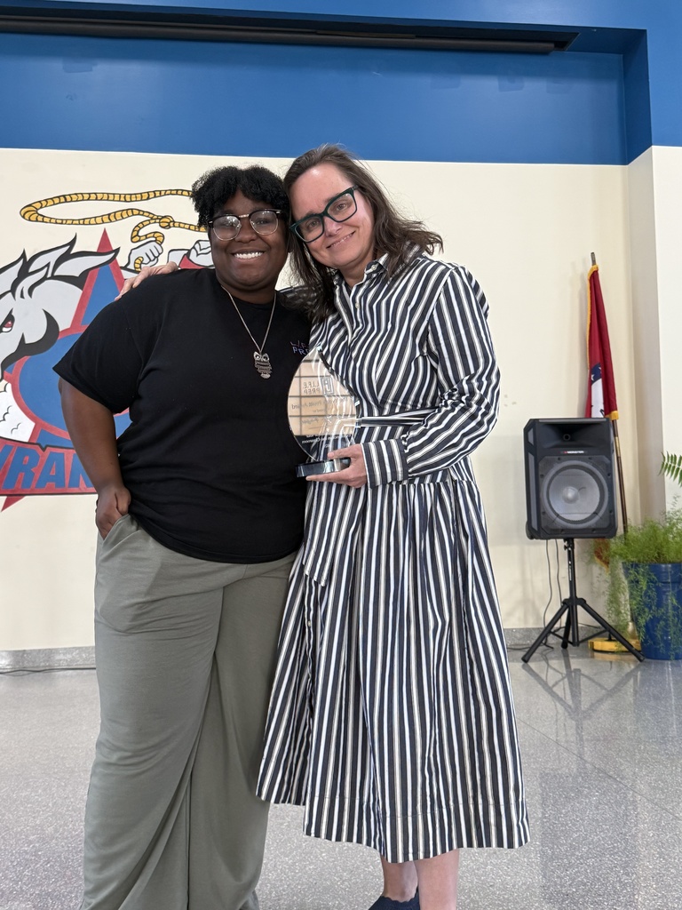 student and teacher posing with award 