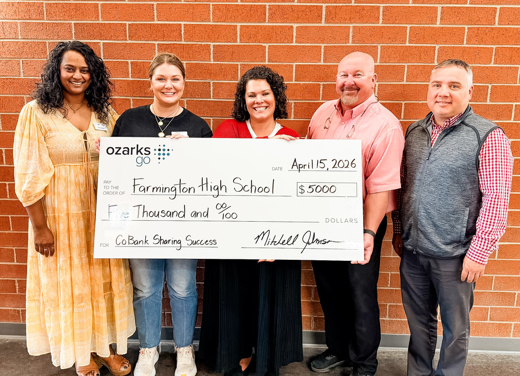 people posing with a giant check