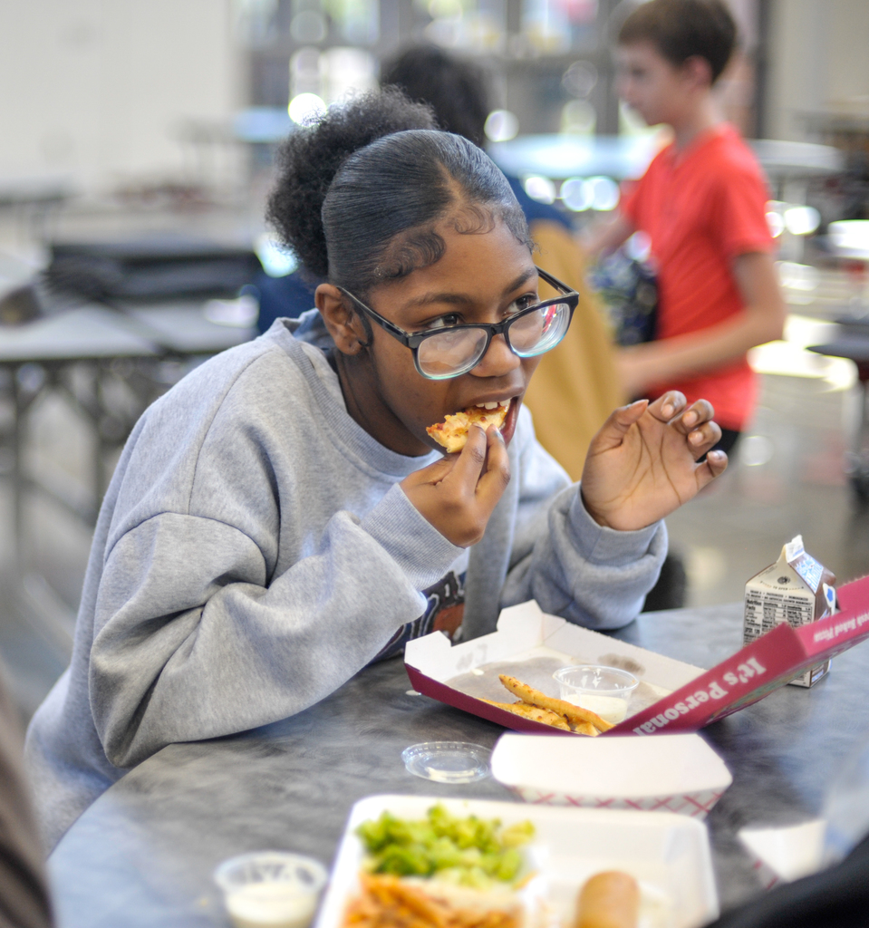Student eating pizza in cafeteria
