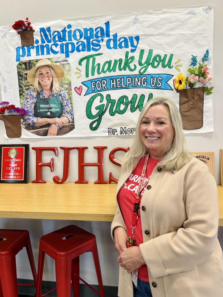 Dr. Morris standing in front of banner on Principals' Day