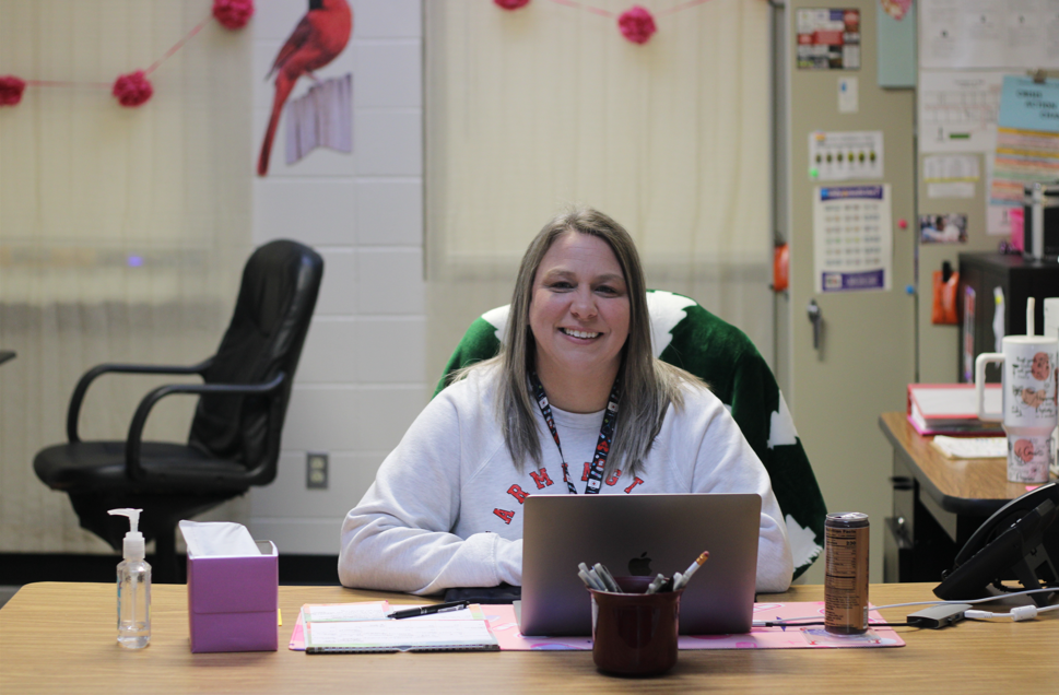 Nurse sitting at her desk smiling.