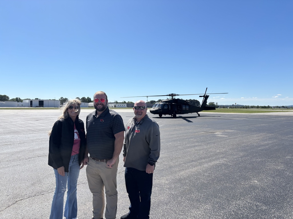 administrators in front of black hawk 