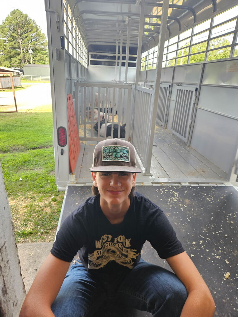 student posing with pigs