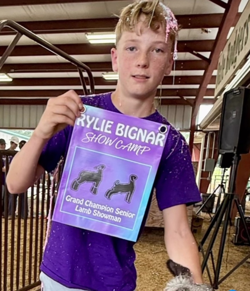 student posing with banner