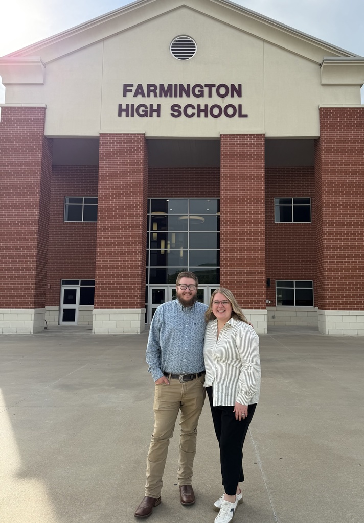 teachers posing in front of high school