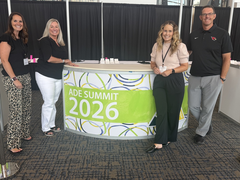 Five people stand behind a table with the text "ADE Summit 2026" on it. Three women and two men.