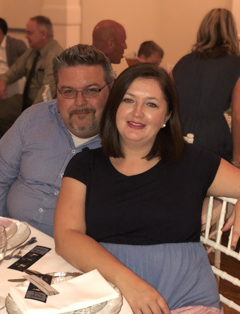 Mrs. Brown posing with her husband at a table