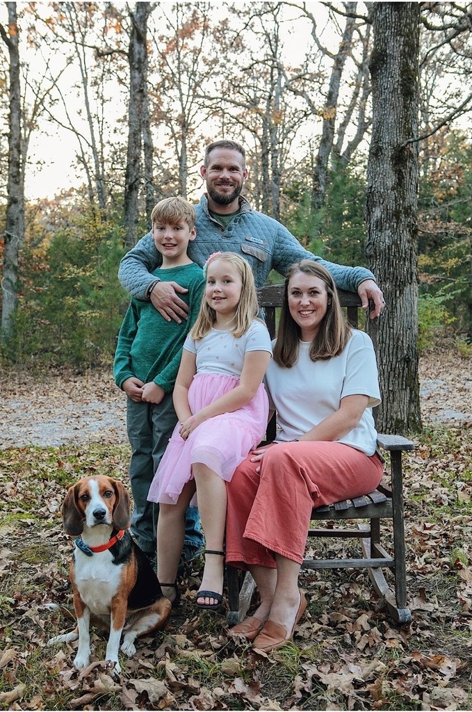 teacher posing with family in forest