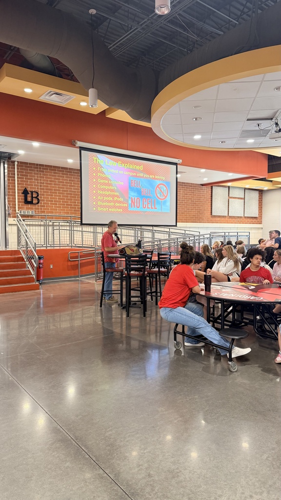 administrator presenting to students in cafeteria
