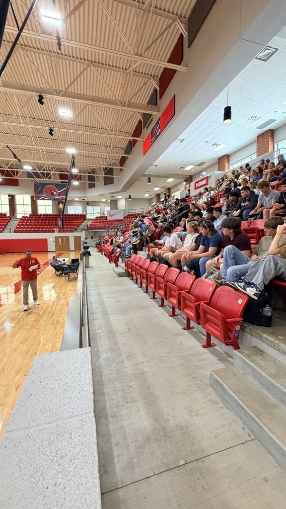 administrator presenting to students in arena