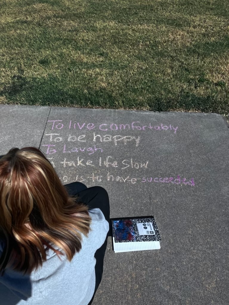students writing a poem on the sidewalk in chalk