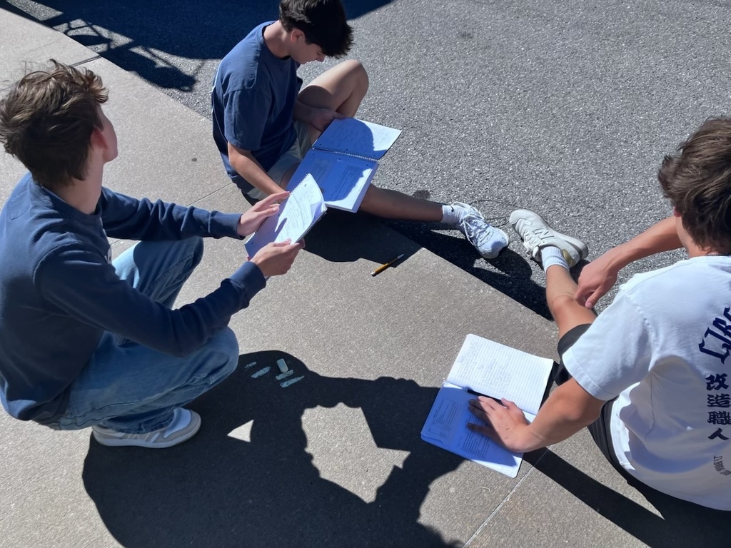 students writing a poem on the sidewalk in chalk