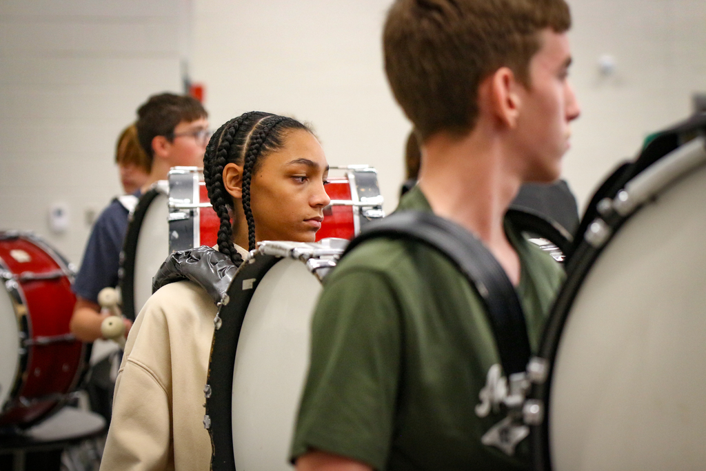 A boy in a room with bass drum.