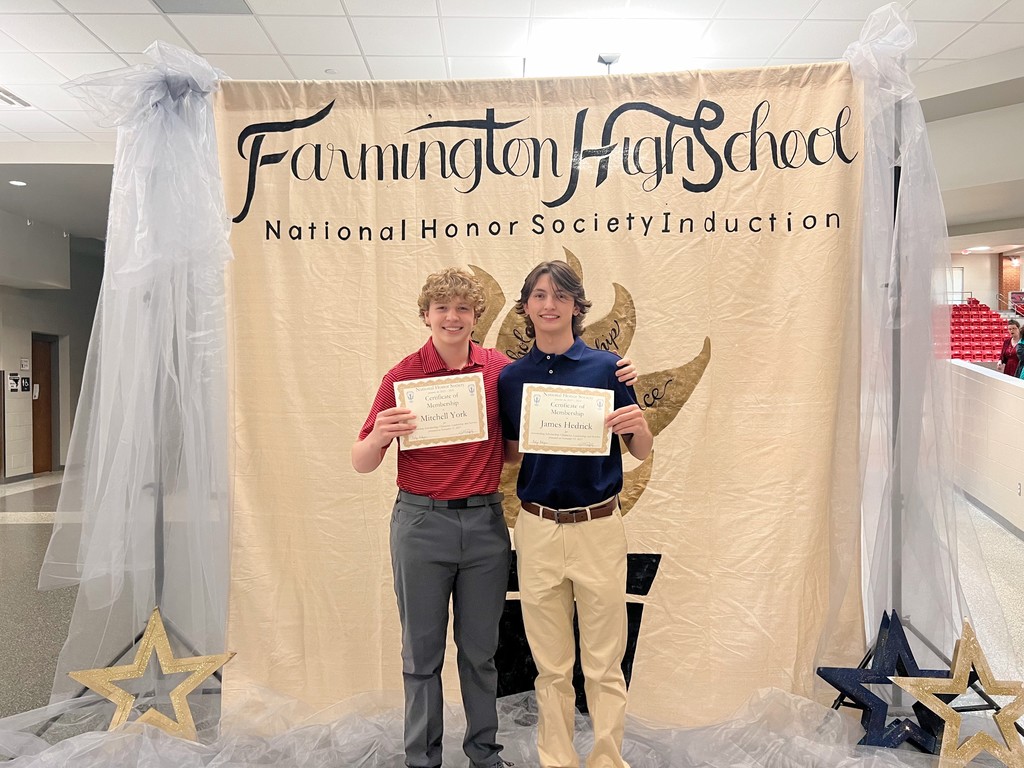 students posing with certificate in front of banner