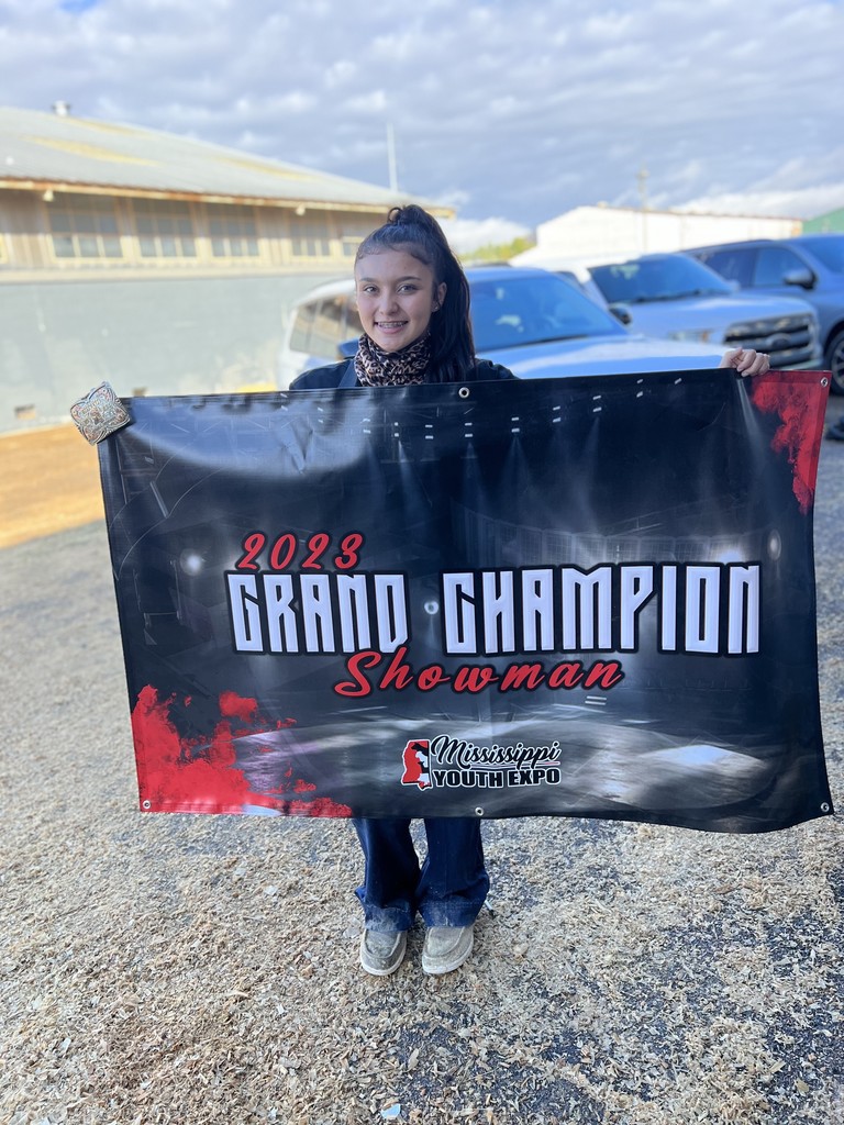 student posing with banner