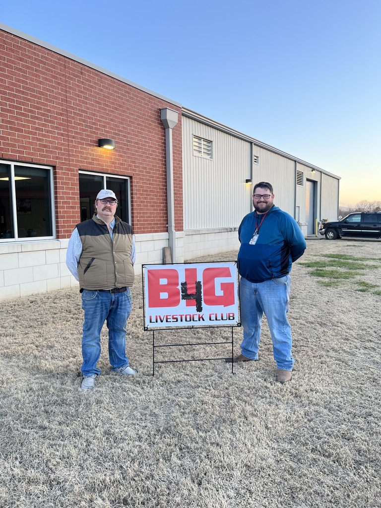 teachers posing by sign 