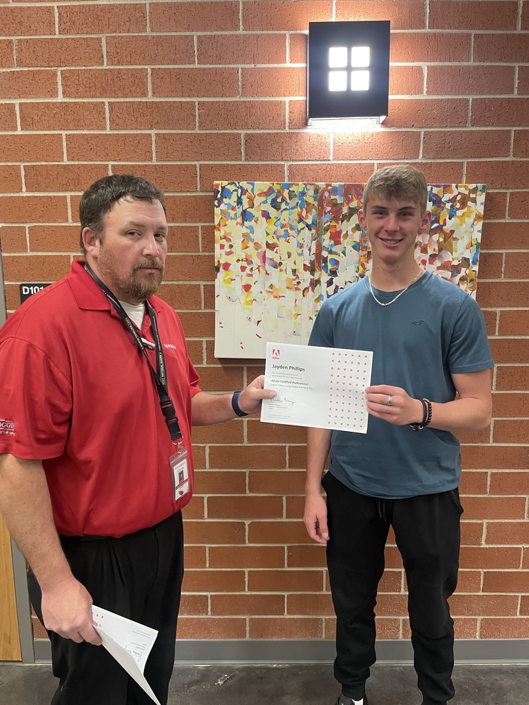 student posing with teacher and certificate