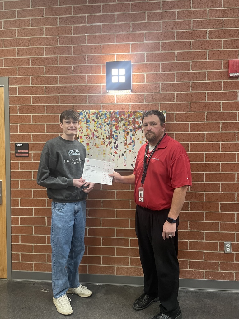 student posing with teacher and certificate