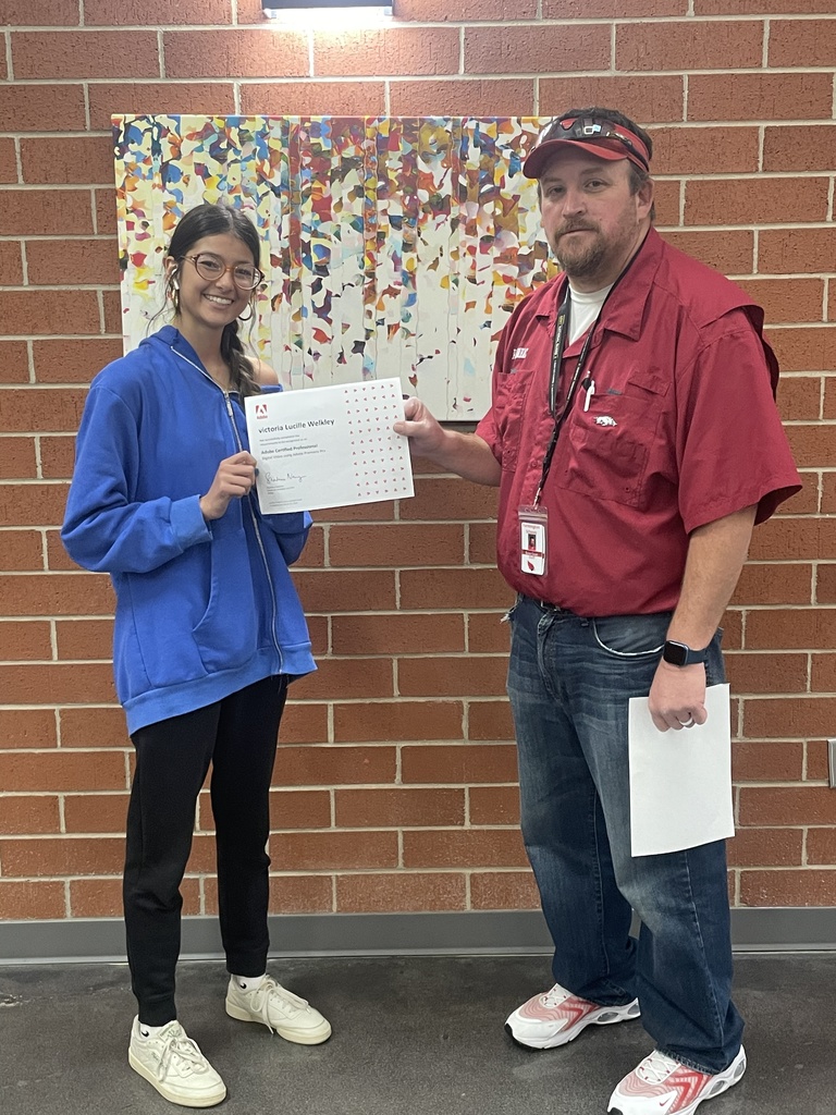 student posing with teacher and certificate