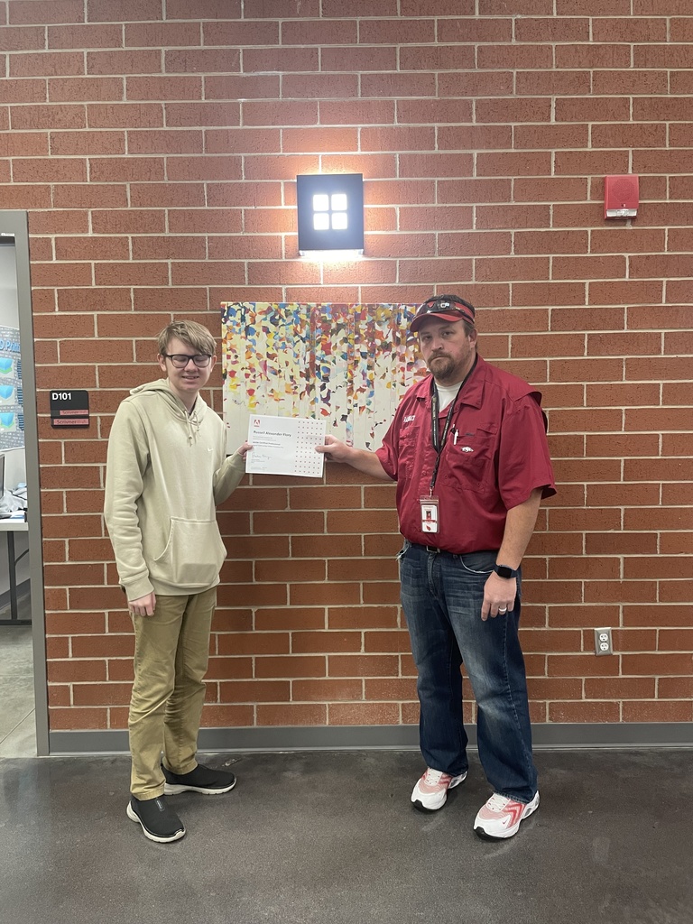 student posing with teacher and certificate