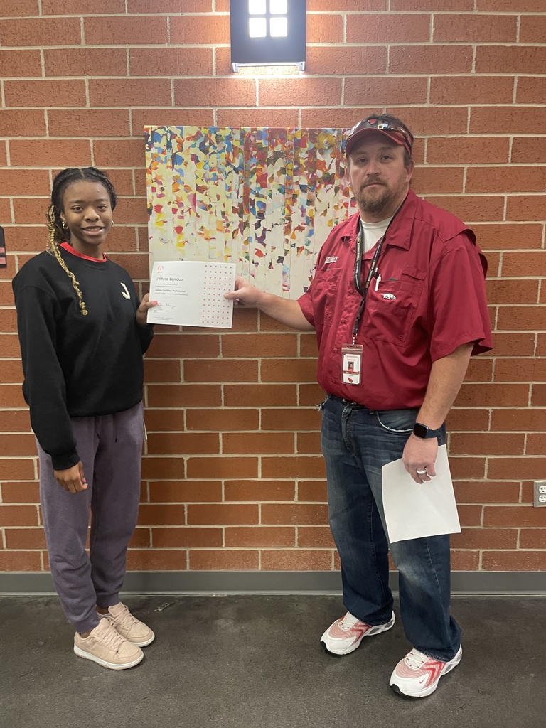 student posing with teacher and certificate