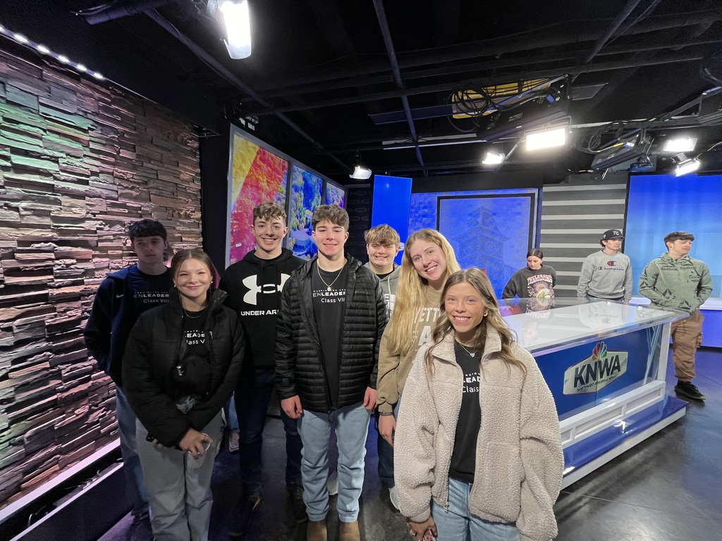 students posing at news desk