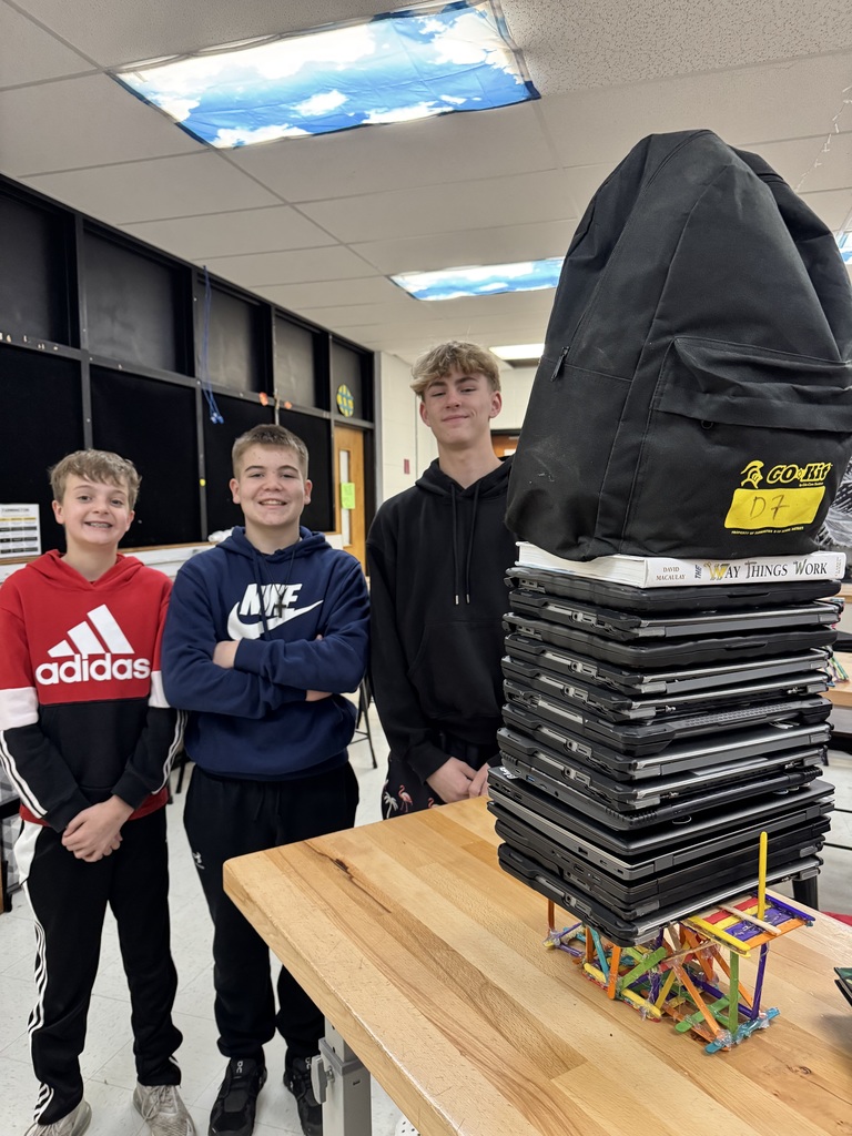 winning weight bearing bridge showing 3 smiling students and their bridge holding 15 chromebooks