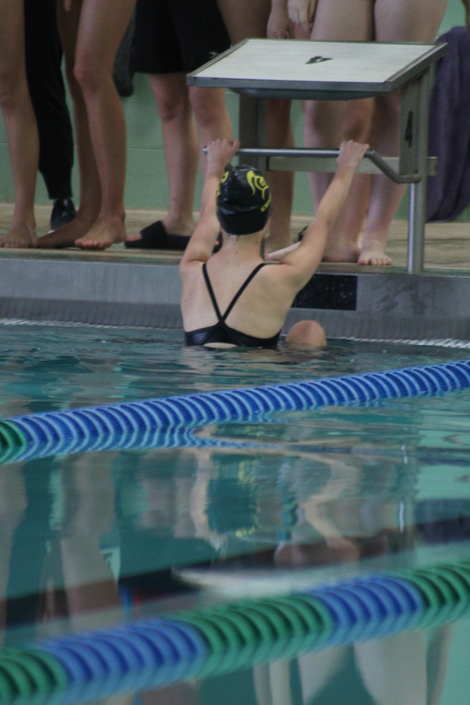 female swimmer preparing to start a race in the water at the board
