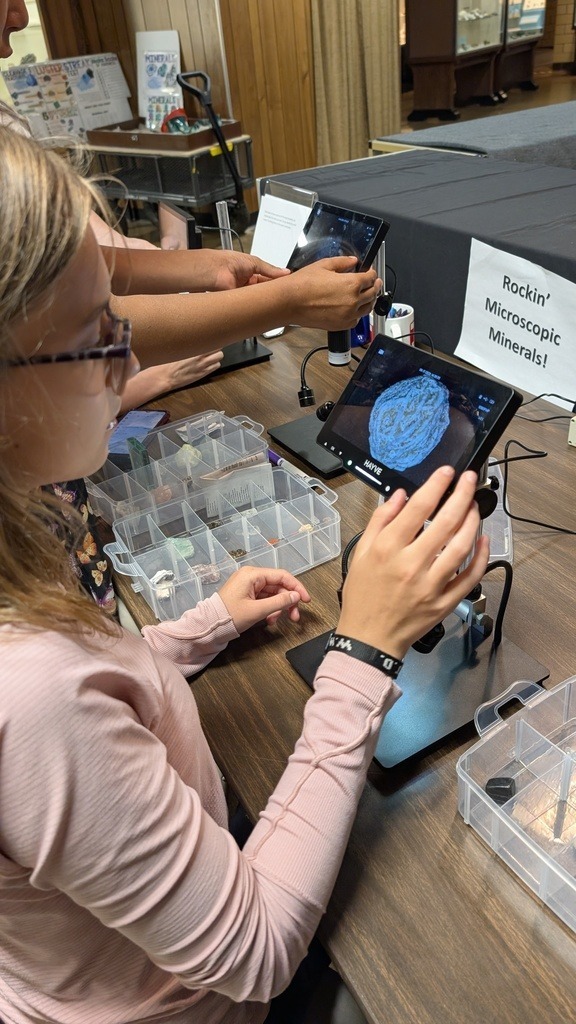 student looking at minerals through microscope