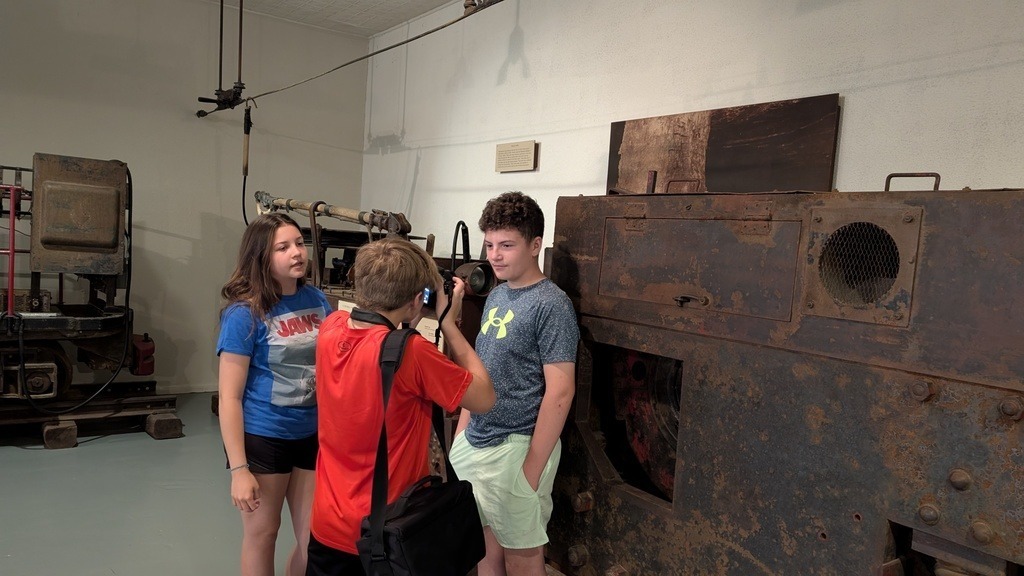 students posing in front of mining equipment