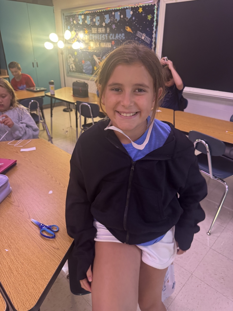 Students with index cards over their heads after completing a classroom activity.