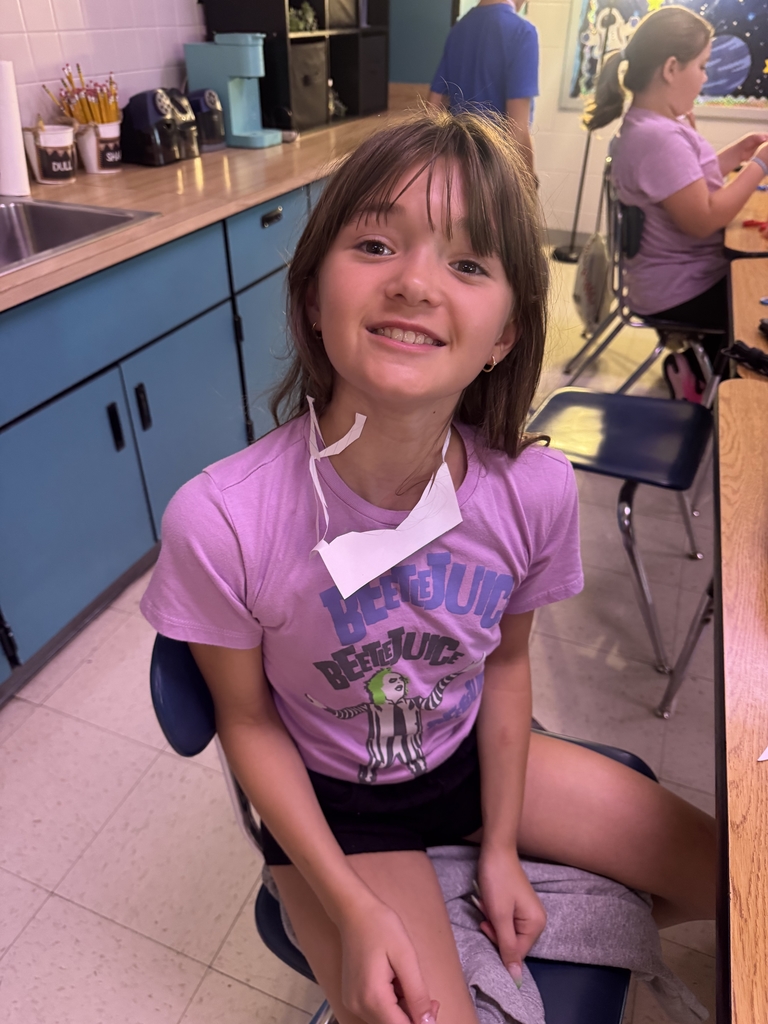 Students with index cards over their heads after completing a classroom activity.
