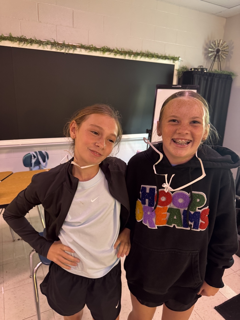 Students with index cards over their heads after completing a classroom activity.