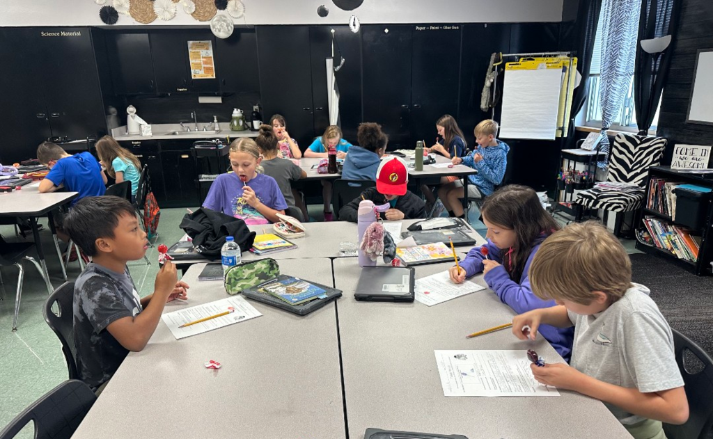 Students completing a science experiment with Tootsie Pops.