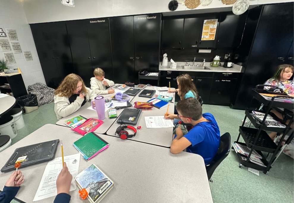 Students completing a science experiment with Tootsie Pops.