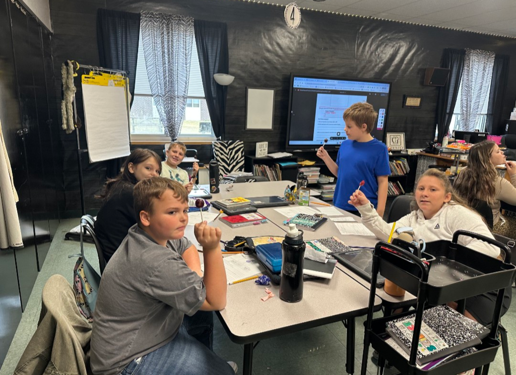 Students completing a science experiment with Tootsie Pops.