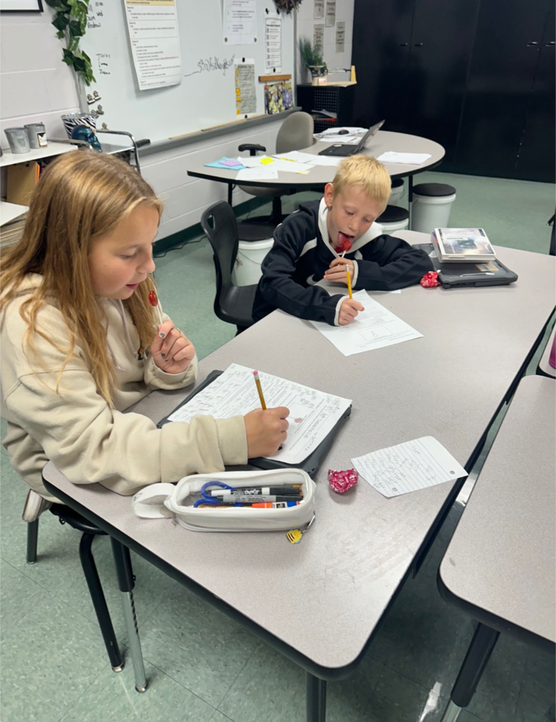 Students completing a science experiment with Tootsie Pops.
