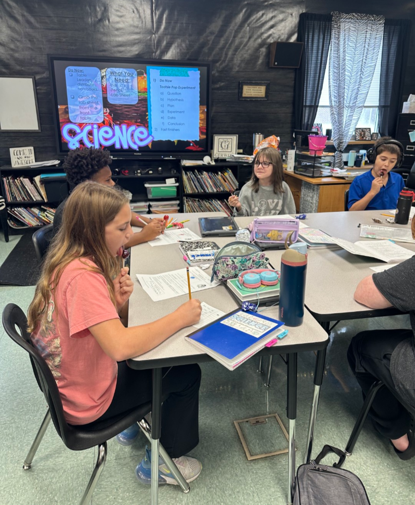 Students completing a science experiment with Tootsie Pops.