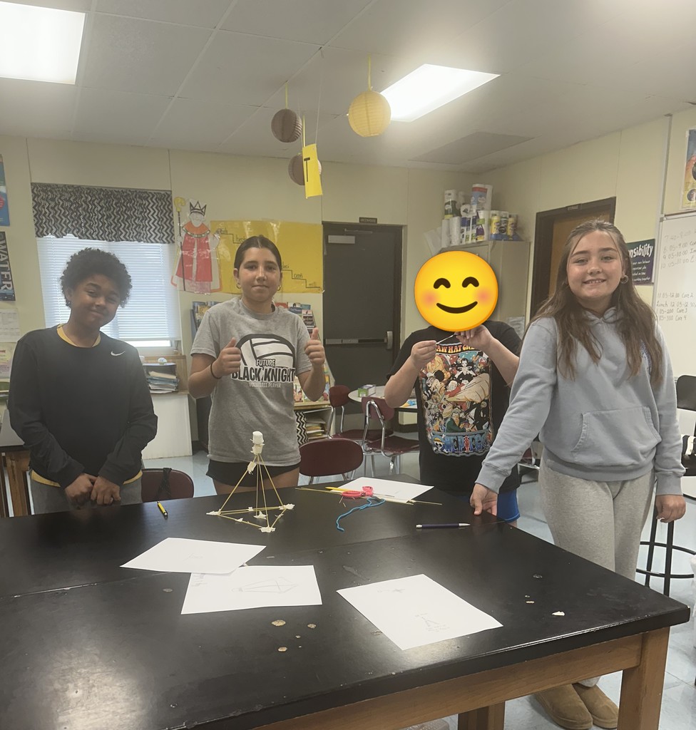 Students engaged in an engineering design challenge, building tall towers out of spaghetti and marshmallows while working in small teams.