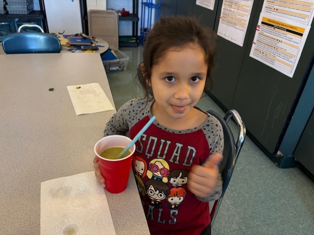 student drinking a green smoothie