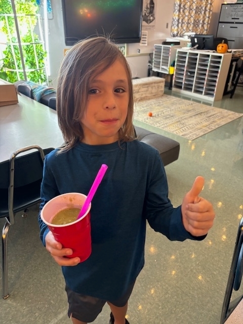 student drinking a green smoothie