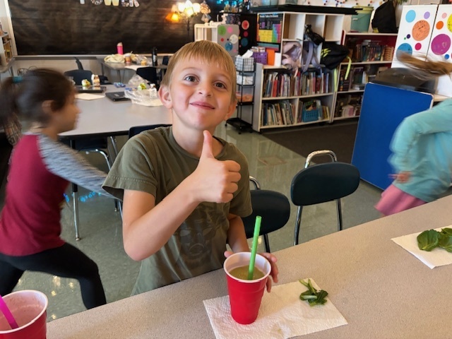 student drinking a green smoothie